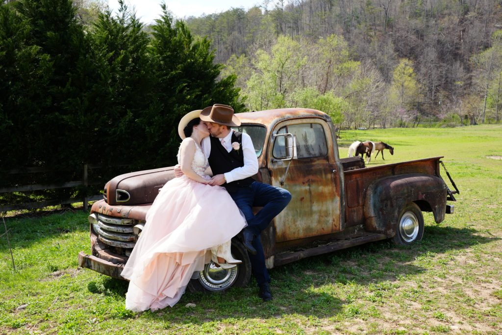 Couple kissing on top of a 1950 Ford wedding truck prop in Gatlinburg