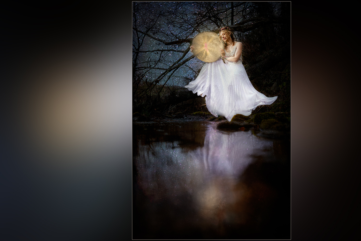 Bride fantasy portrait holding the moon with a soft reflection in a creek under the night sky with stars