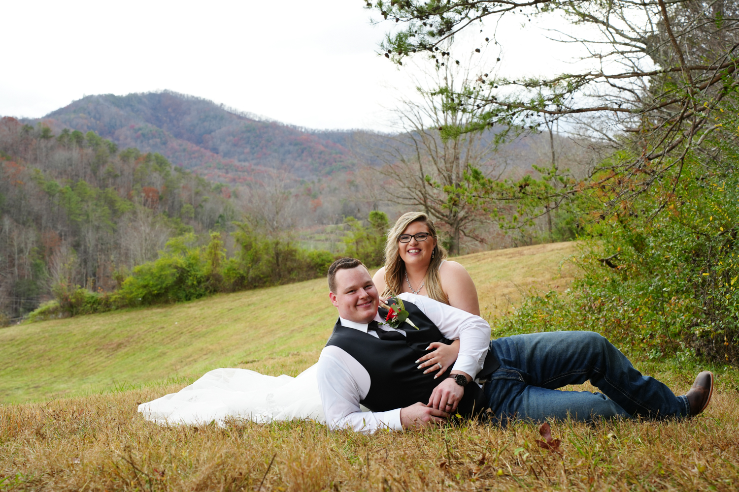 Wedding couple sitting in front of a mountain meadow view