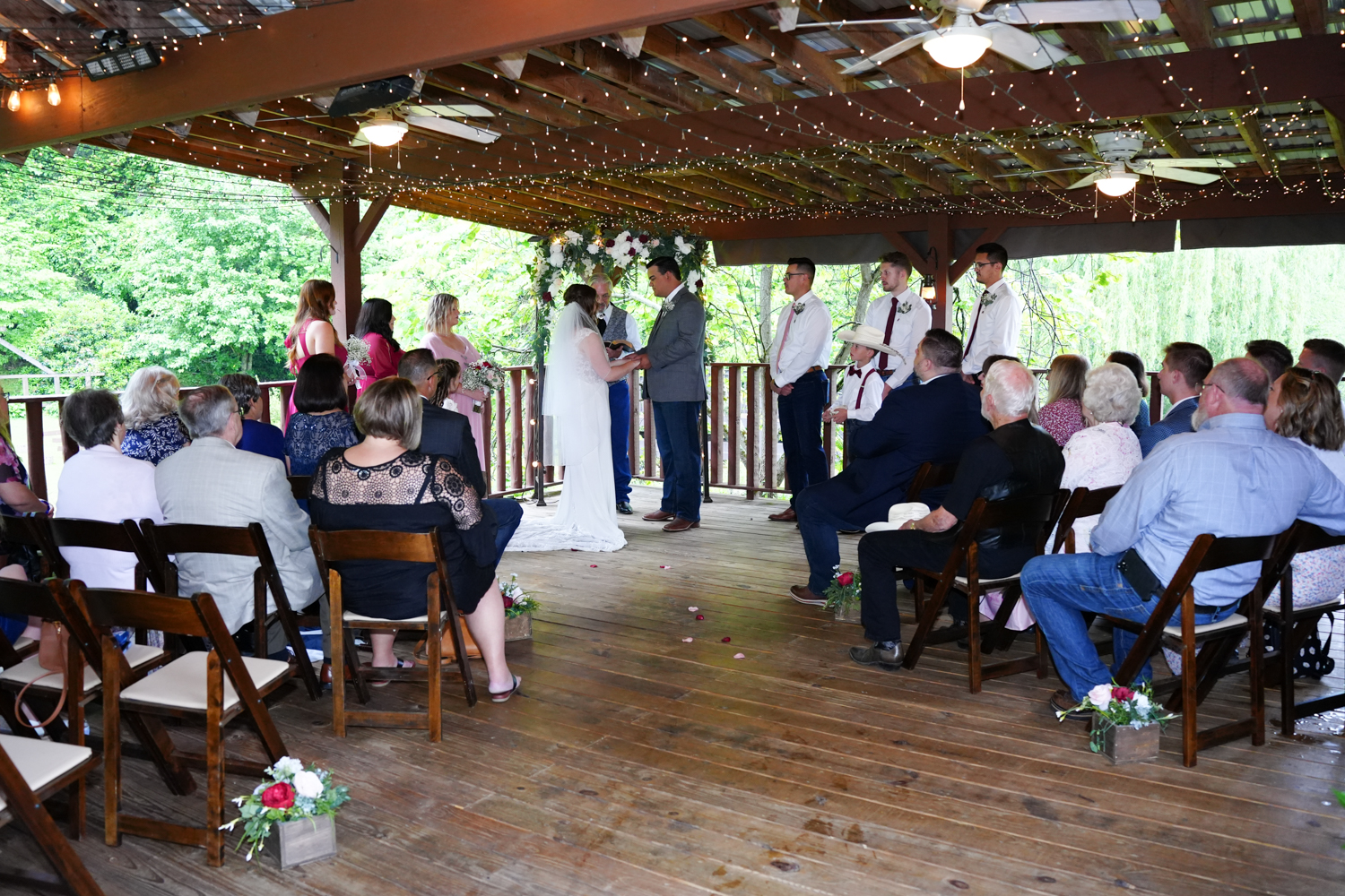 wedding with guests in wooden folding chairs under a pavilion in the Smoky Mountains