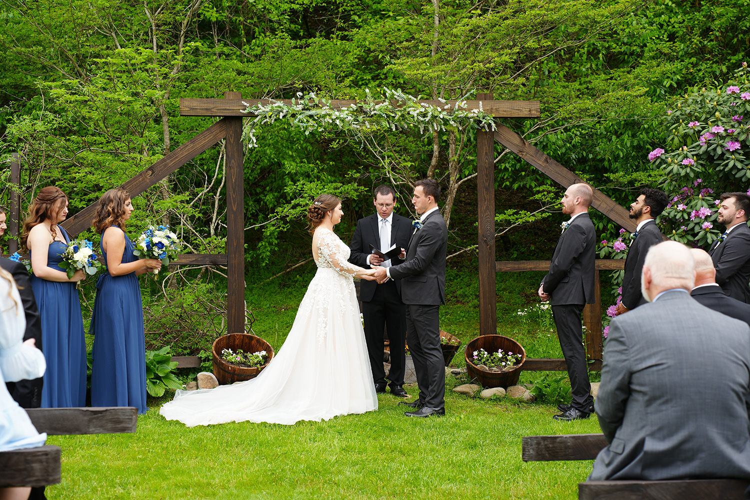 summer wedding at a wooden wedding arbor in the mountains