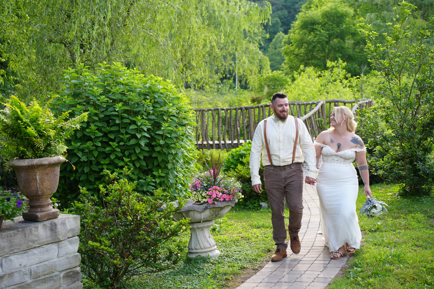 Casual wedding couple walking along the garden path at Honeysuckle Hills in Pigeon Forge