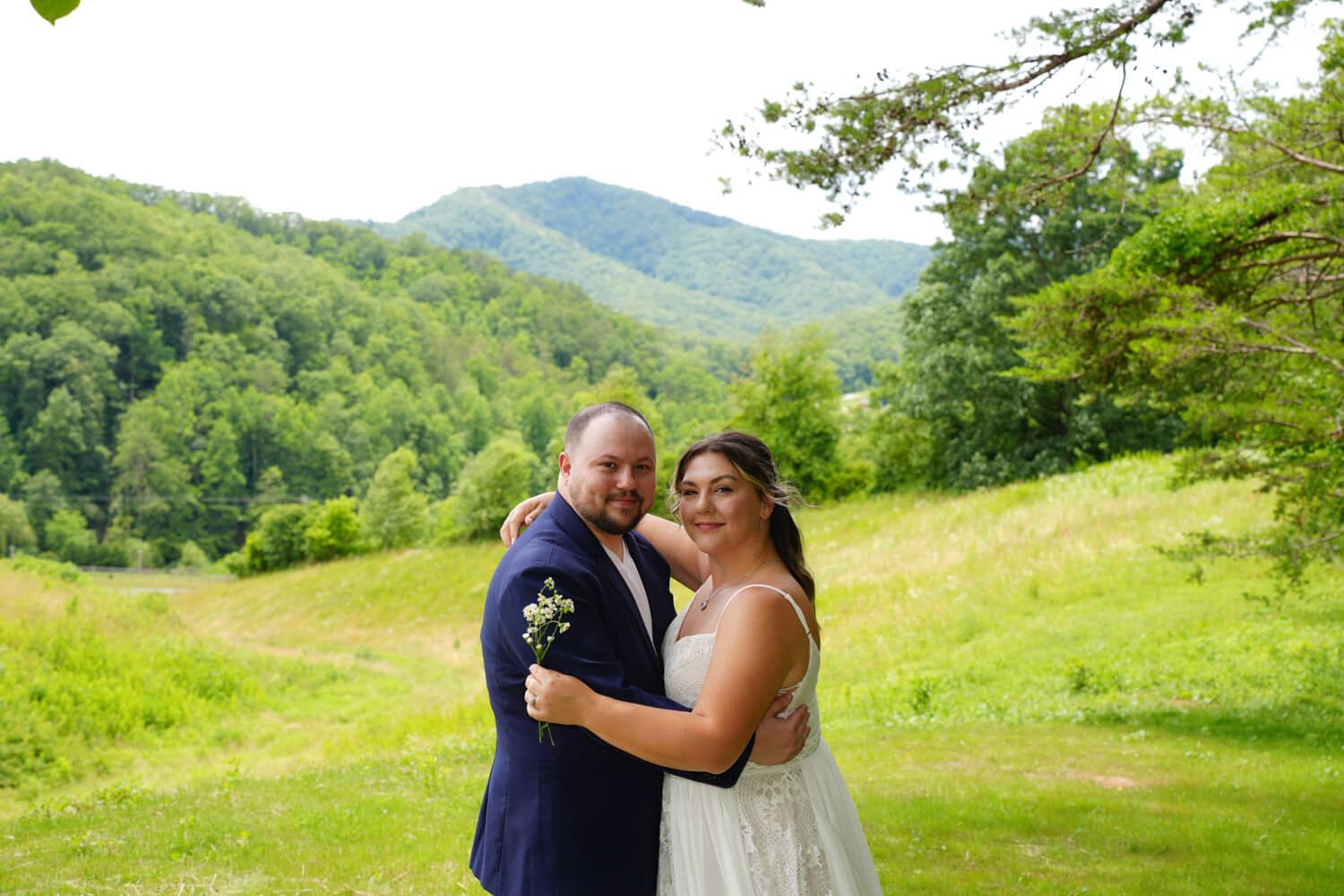 Couple holding each other closely on their wedding day for a photo at the mountain meadow view at Honeysuckle Hills