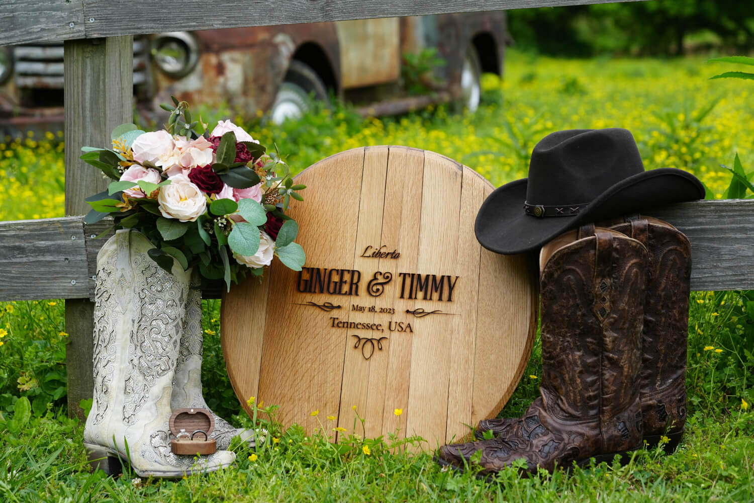 Wedding boots and welcome sign made from the top of a whiskey barrel with their names on it