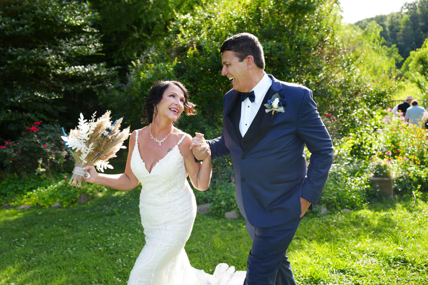 Bride and Groom walking from their ceremony site holding hands and laughing with joy