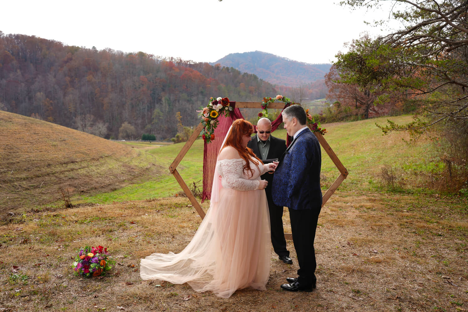 Wedding couple getting married in late fall in a field with a mountain view at Honeysuckle Hills in the Smoky Mountains