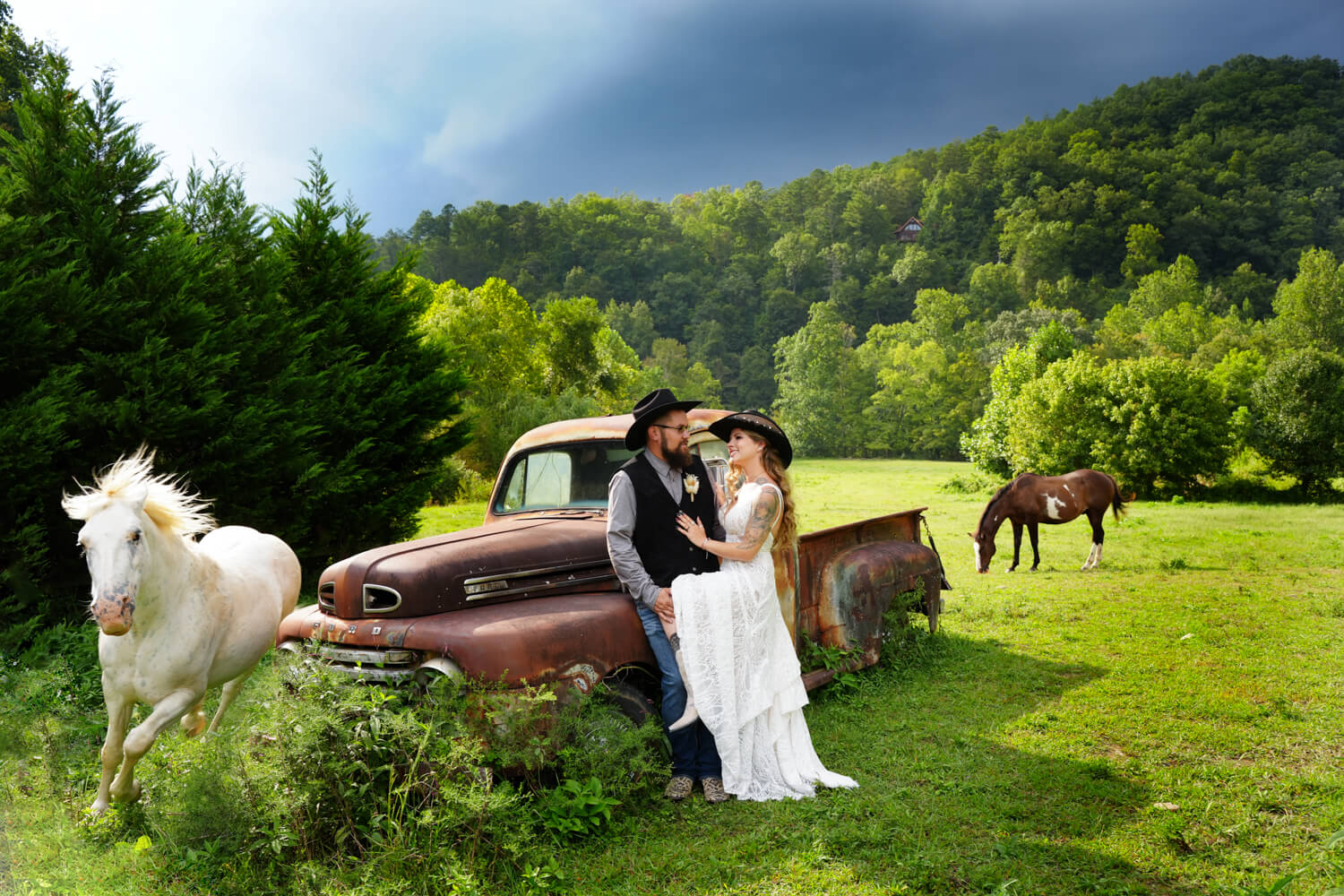white horse running past an old 1950 Ford truck with a deep blue sky and a groom holding his bride's leg as they look into each others eyes