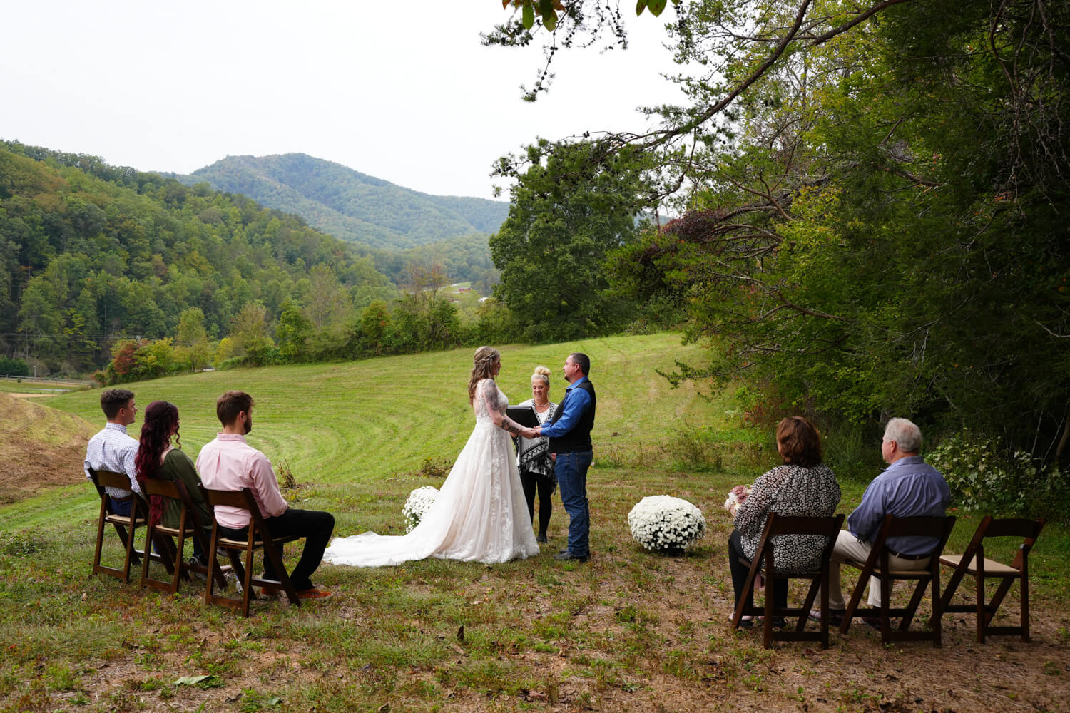 Mountain view ceremony in Gatlinburg with guests sitting in dark wooden folding chairs in the fall