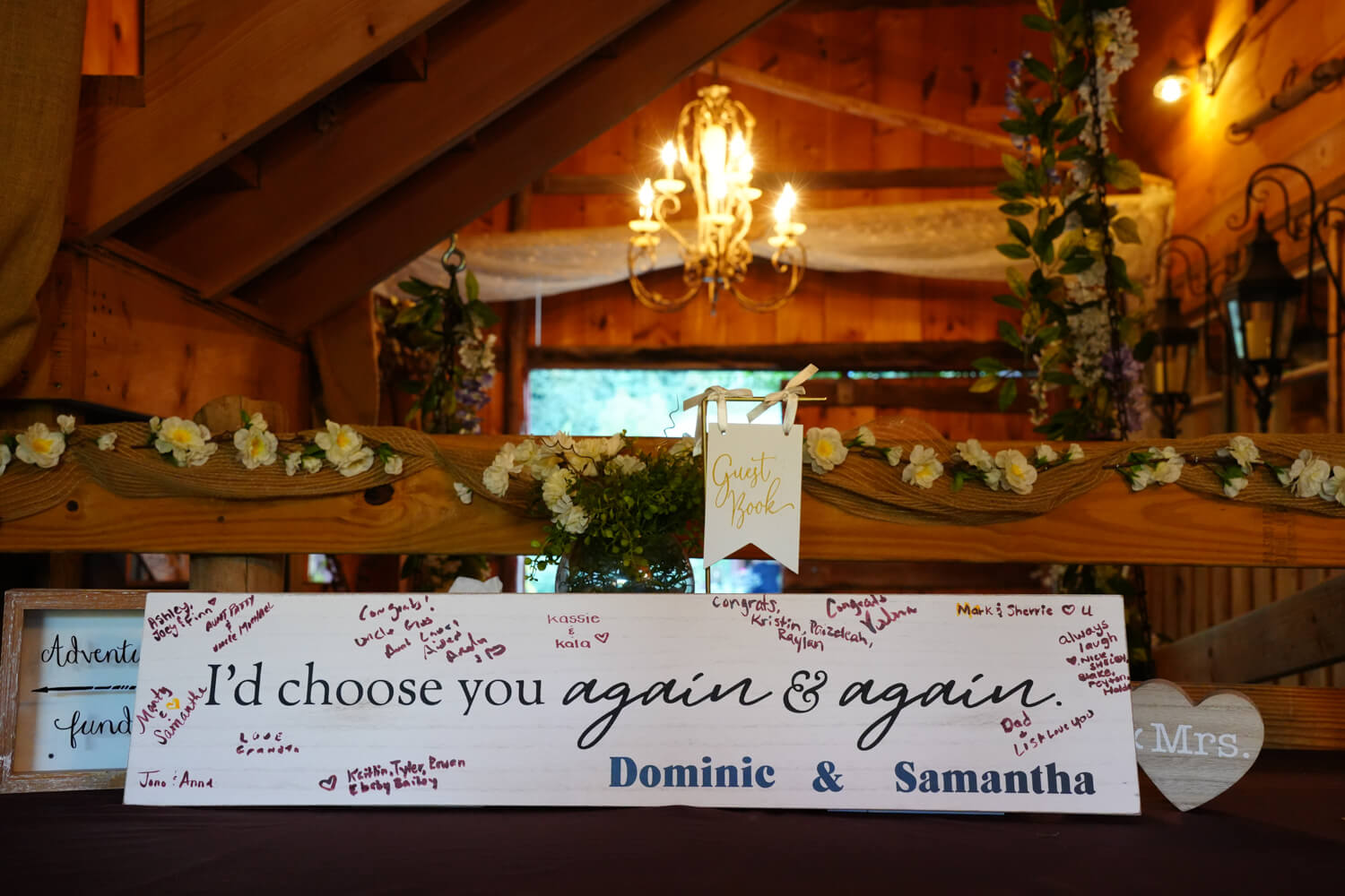 I'd Choose You again and again signed by all wedding guests sitting beneath a vintage chandelier in a country wedding venue in Pigeon Forge