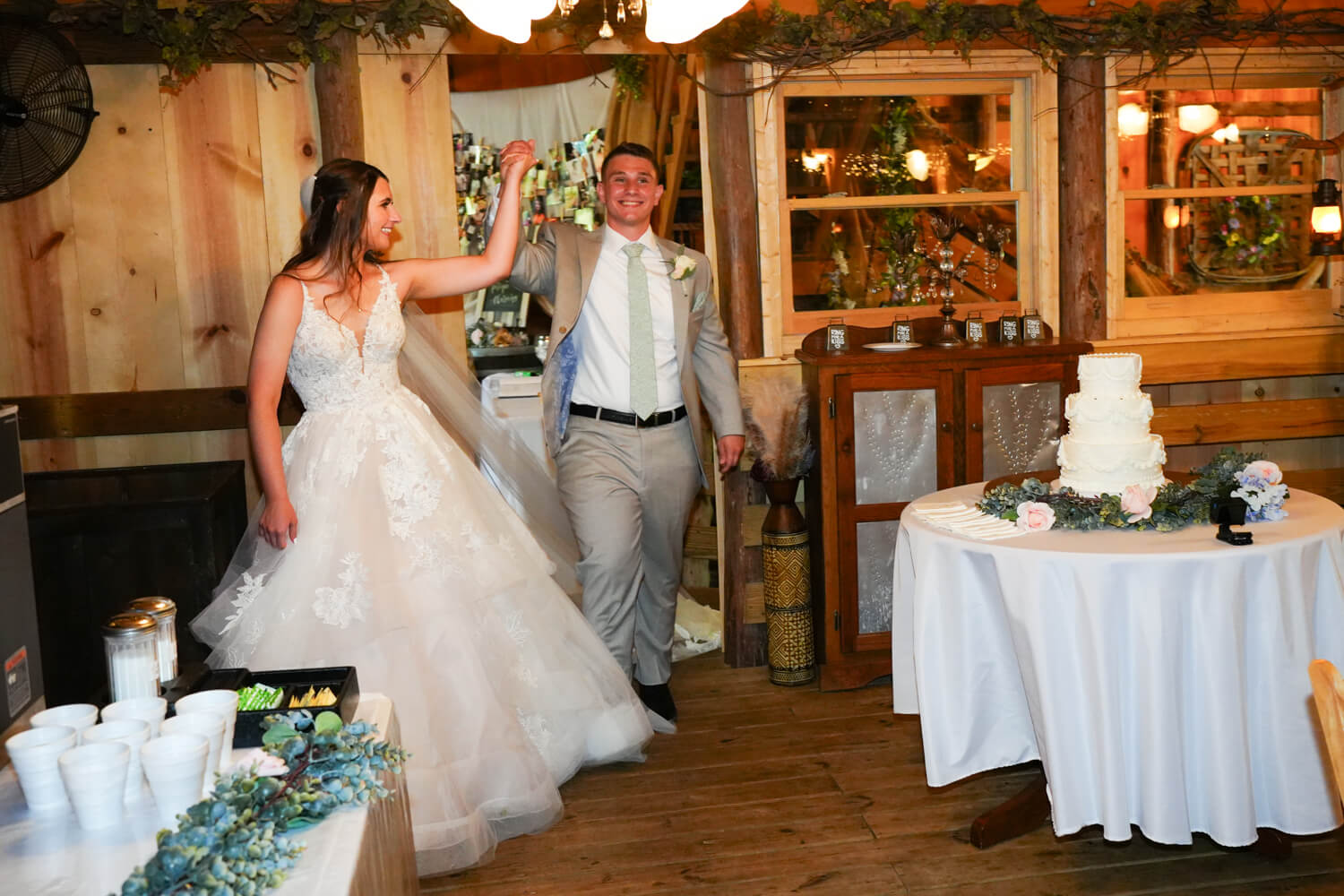 Wedding couple entering the reception hall in a country chic barn venue atmosphere
