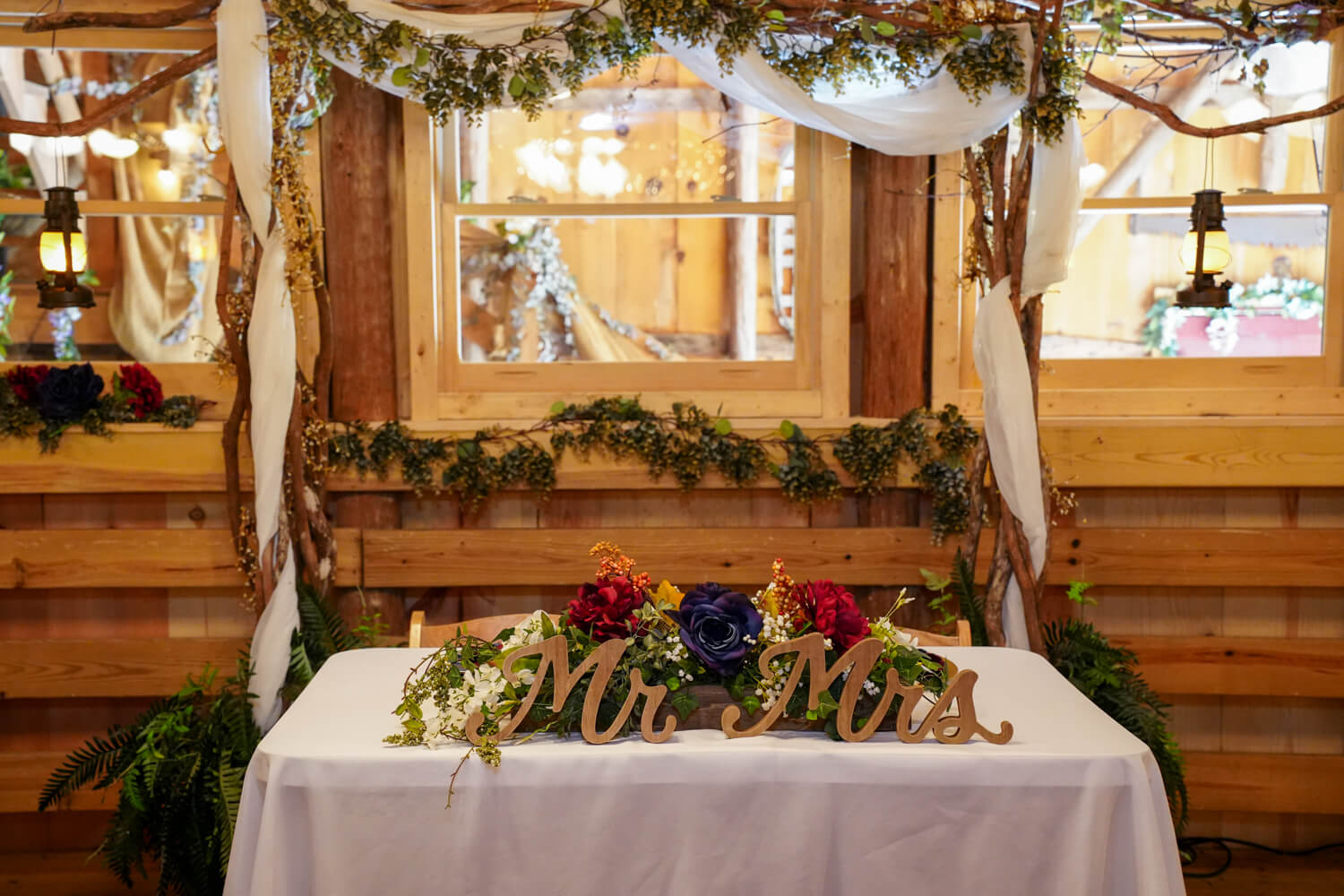 Head table with Mr. and Mrs. Sign in a country barn wedding reception venue