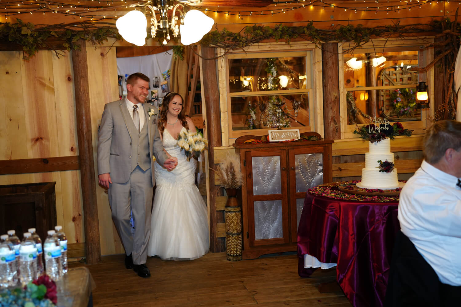 Bride and groom entering the reception area of a barn wedding venue in Pigeon Forge with country chic decor