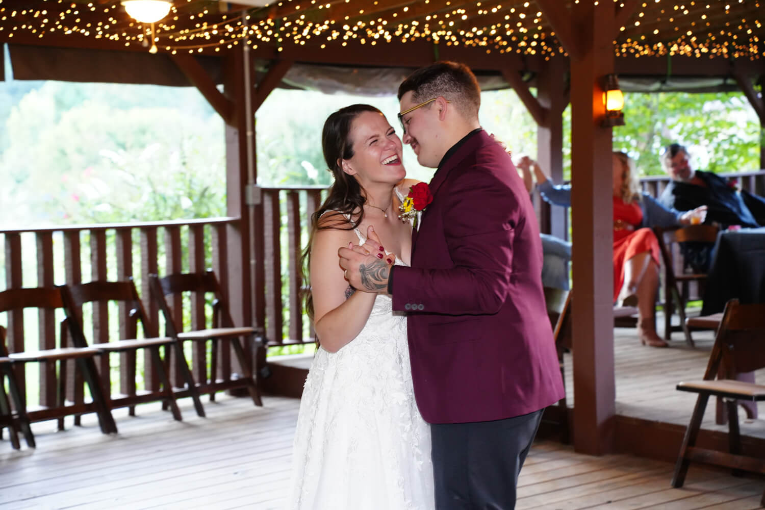 Bride and groom doing their first dance in a country pavilion with string lights