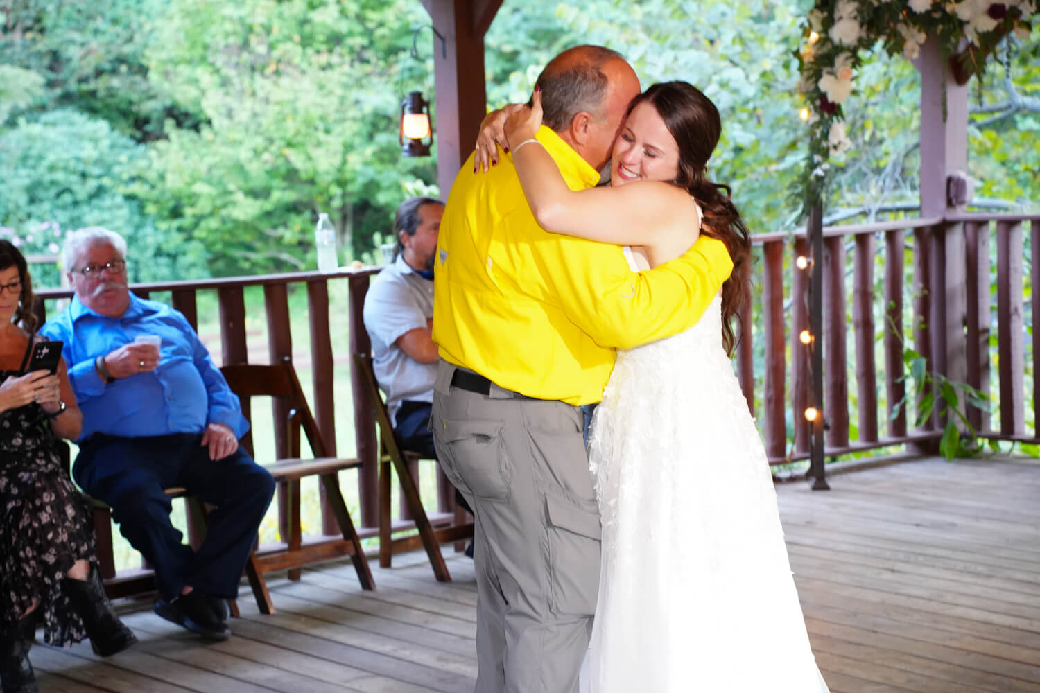 Bride dancing with her father in a covered pavilion in the country