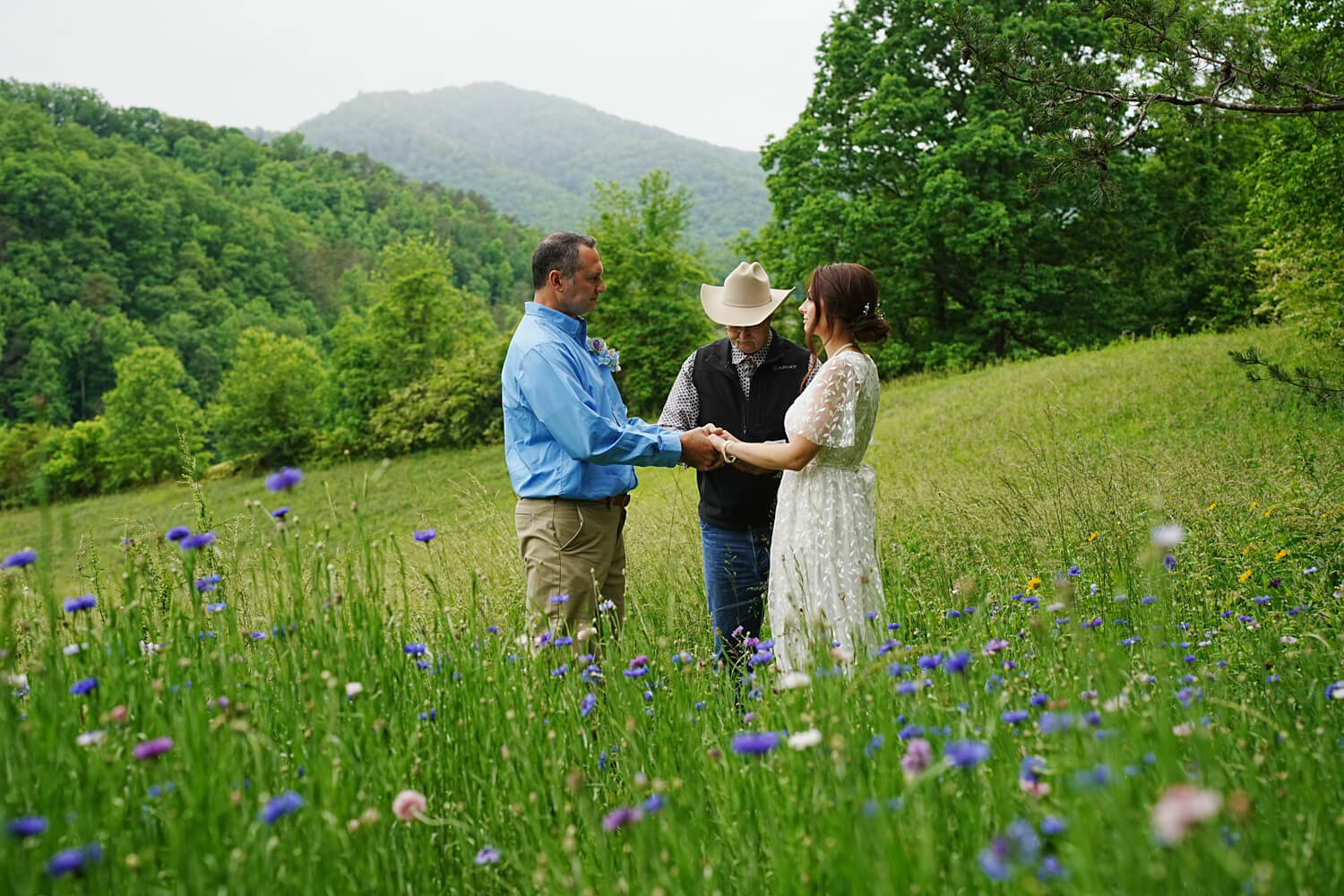 Couple getting married in a field of wildflowers at a mountain view