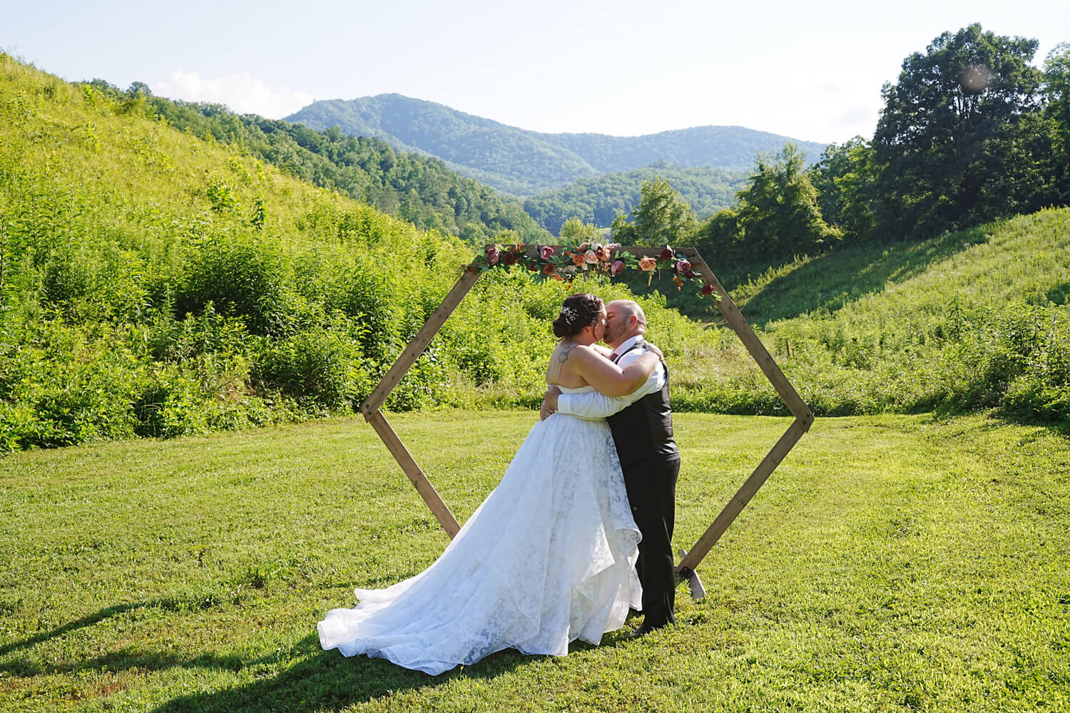 Wedding Couple kissing in front of a hexagon arbor at a mountain view