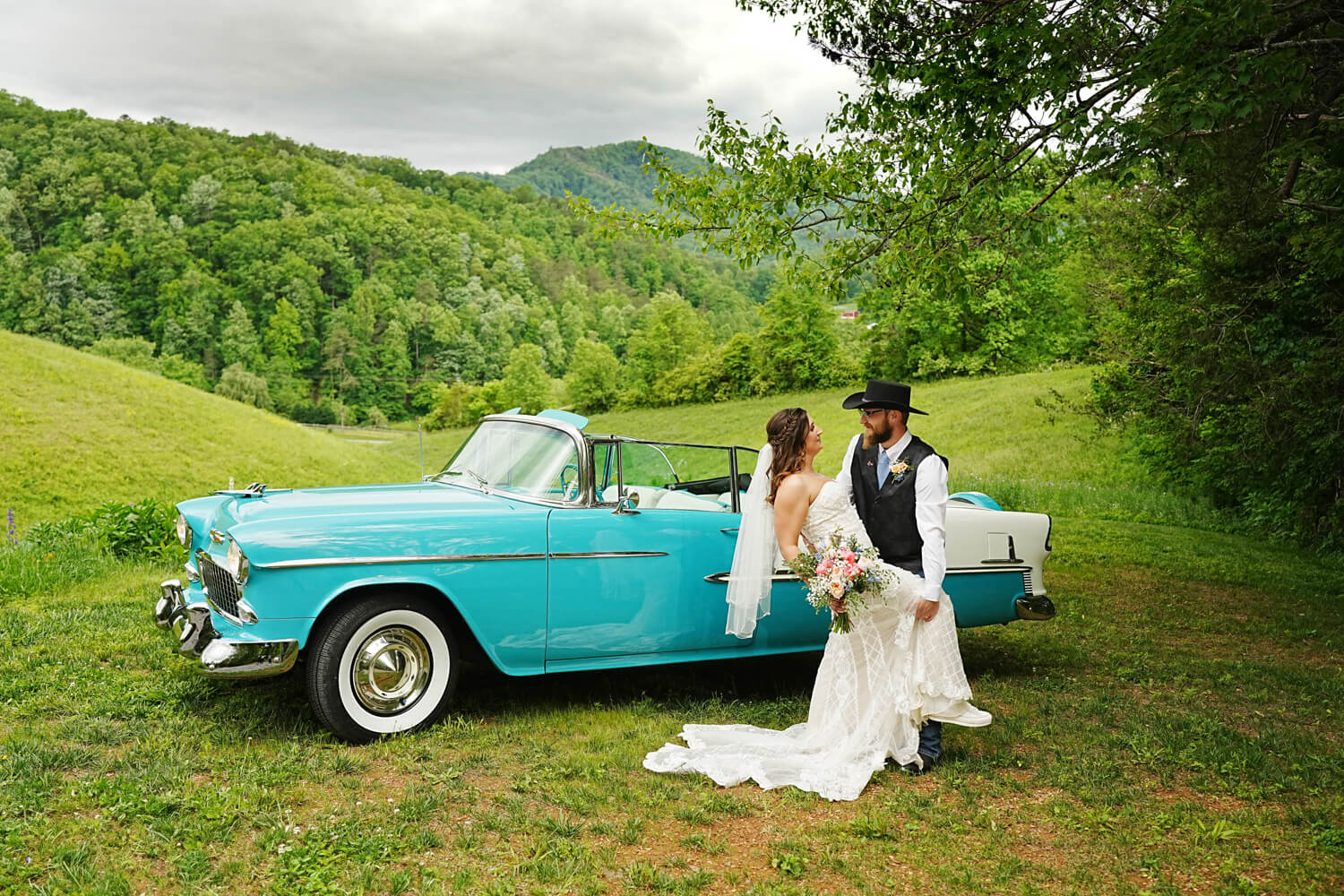 Wedding couple posing in front of a light blue Chevy Bel Air at a mountain view in Pigeon Forge