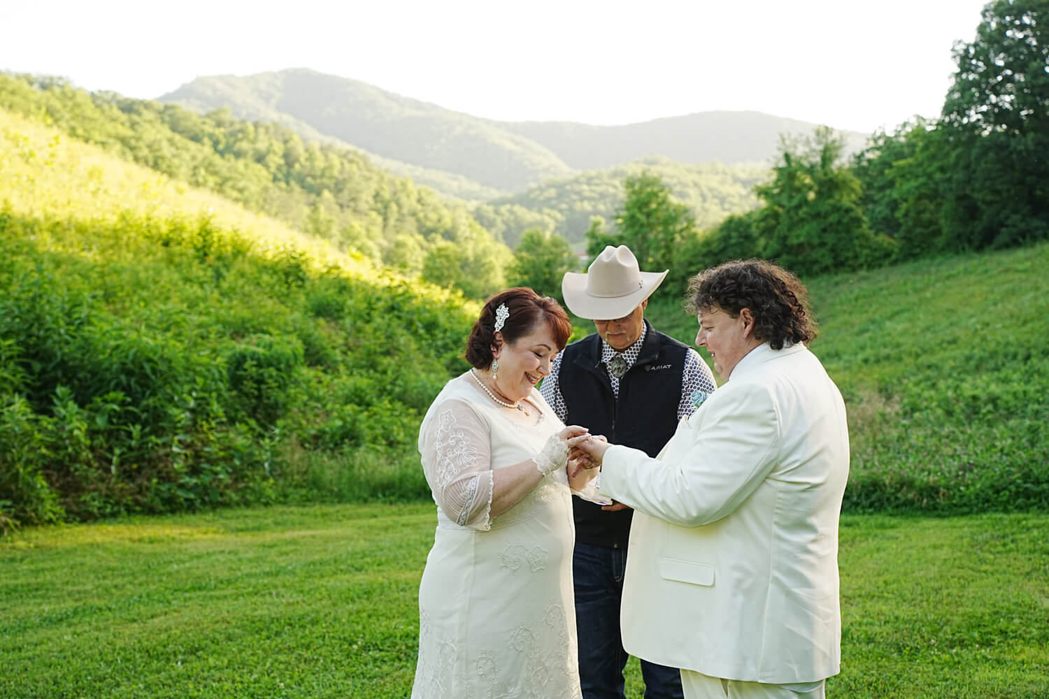 Ring exchange during a wedding in a meadow with a mountain view
