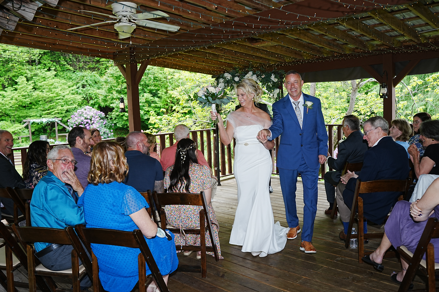 Wedding recessional under a covered pavilion in the spring