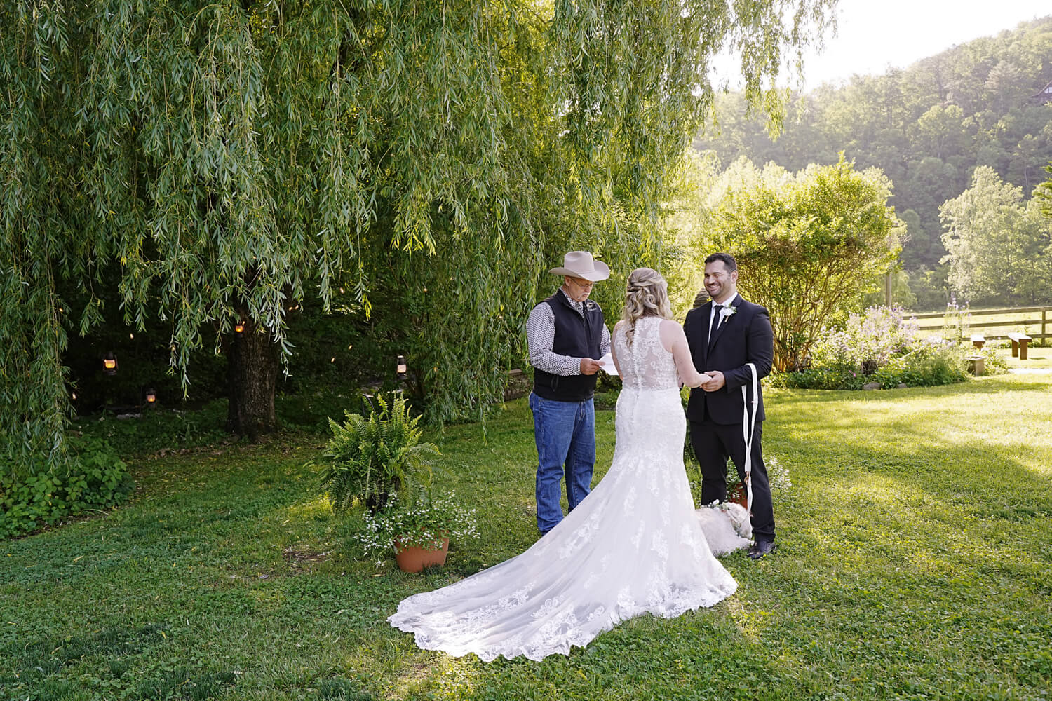 Wedding couple saying their vows under a weeping willow tree in Pigeon Forge Tennessee with their dog