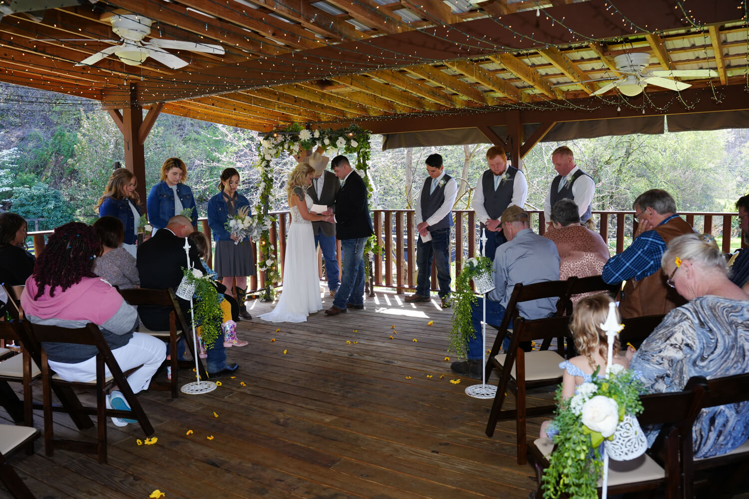 Wedding ceremony under a covered pavilion with twinkling lights on the ceiling