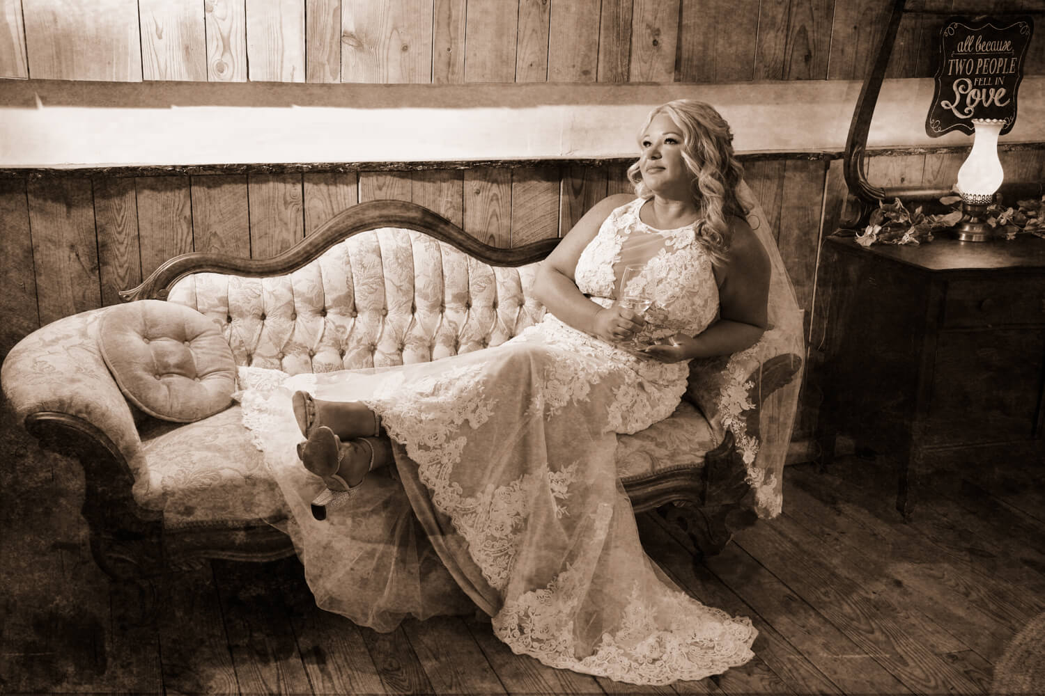 Bride with cowgirl boots leaned back on an antique couch in the bridal suite at Honeysuckle Hills in Pigeon Forge Tennessee