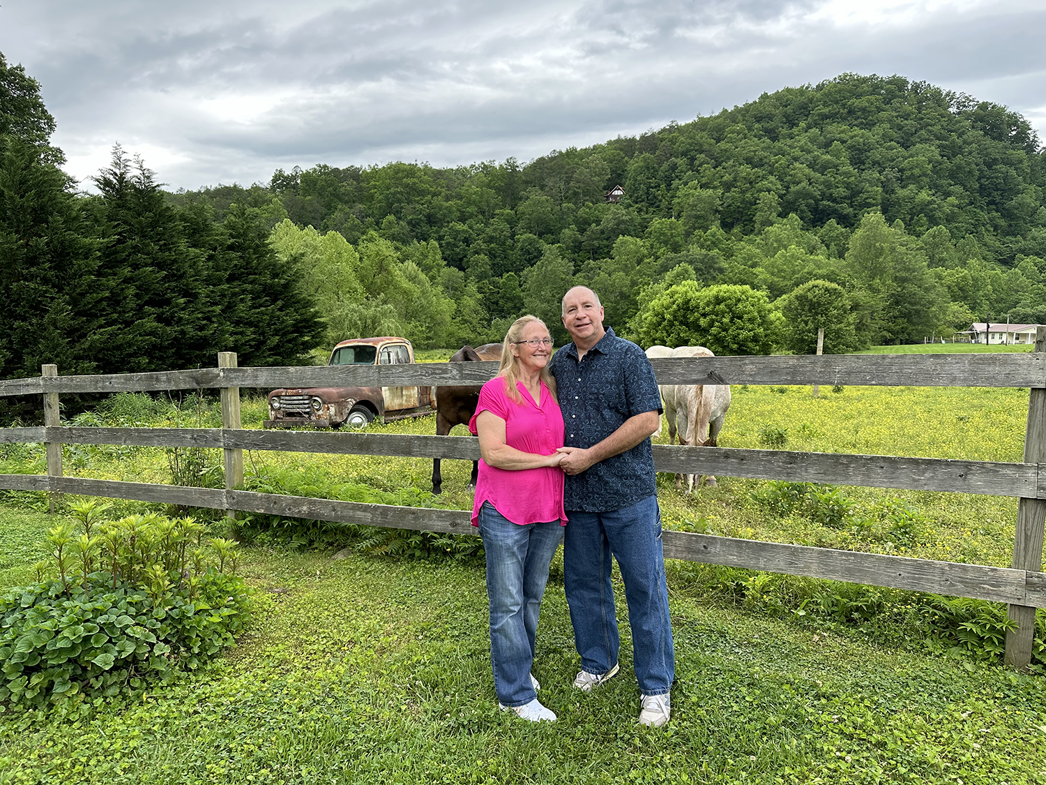 Couple holding hands next to the horse fence at the Honeysuckle Hills wedding venue in Pigeon Forge