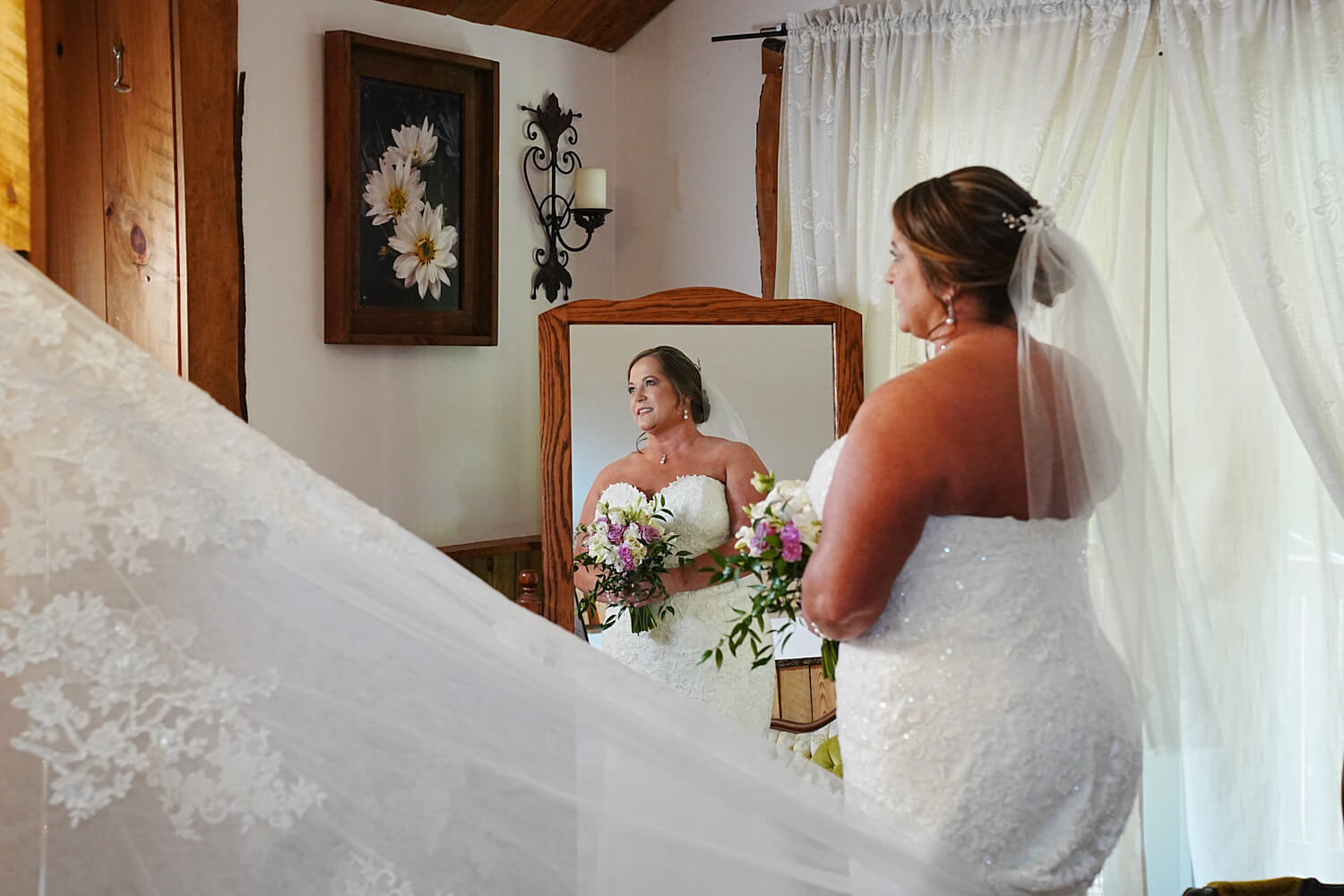 Bride and her reflection in an antique mirror in the bridal suite at Honeysuckle Hills in Pigeon Forge Tennessee