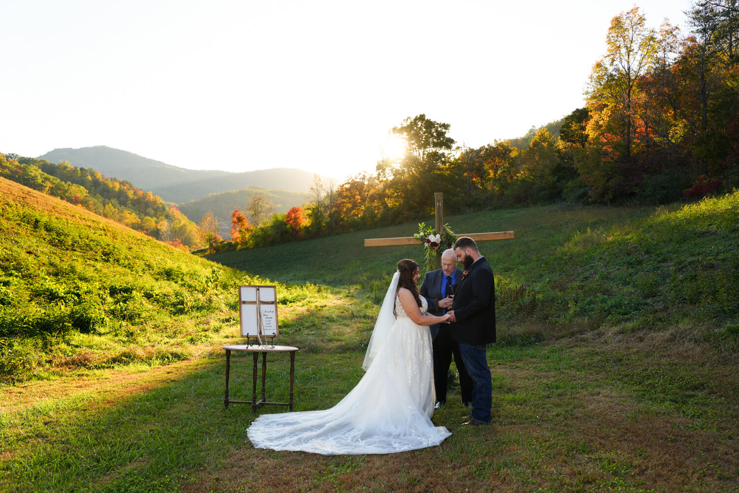 Mountain view ceremony in a field at sunset with a cross and cord of three strands at Honeysuckle Hills in Pigeon Forge