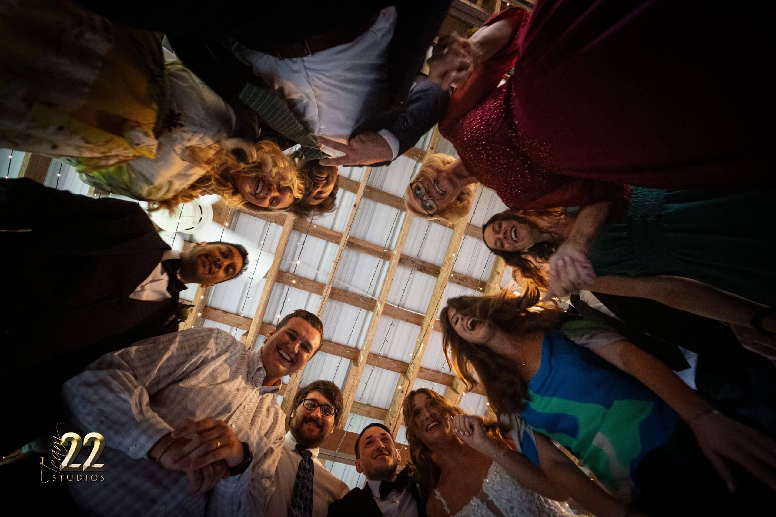 Wedding guests staring down at the photographer on the dance floor at the reception